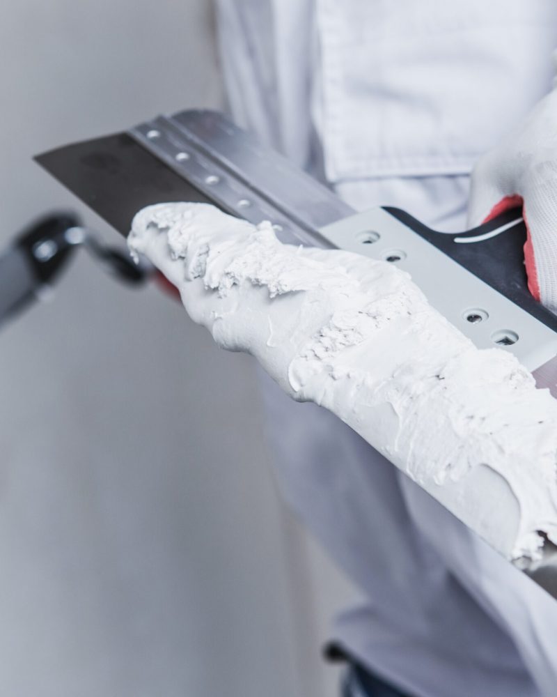Preparing For Drywall Patch. Patching Tools in Hand of Worker Closeup Photo